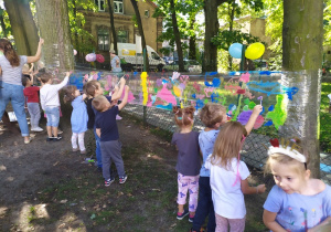 Przedszkolaki malują farbami po folii