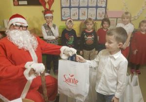 Św. Mikołaj wręcza prezent dziecku