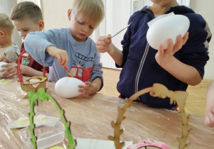 Chłopcy ozdabiają styropianowe jajka