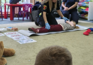 Panie ze Straży Miejskiej pokazują jak ułożyć pacjenta w pozycji bezpiecznej