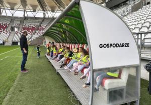 Dzieci siedzą na ławce rezerwowych