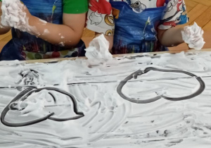 Chłopcy rysują na stoliku, wysmarowanym pianką do golenia, serca