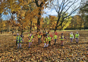 Dzieci podrzucają liście do góry