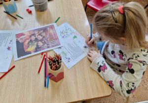 dziewczynka ozdabia kartkę