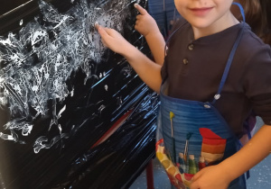 chłopiec z grupy II w trakcie malowania