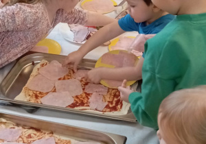 nakładanie przez dzieci składników na pizzę