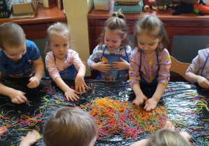 dzieci w trakcie zabaw z wykorzystaniem kolorowego makaronu