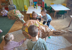 dzieci z grupy I wykonują wspólnie dinozaura